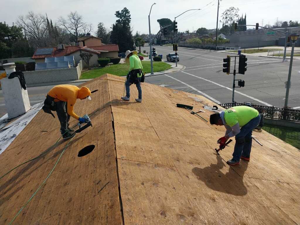 Trabajadores preparando la base de madera de un techo residencial