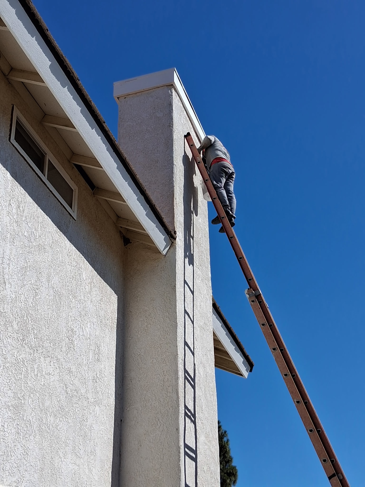 Detalle de trabajador realizando labores en el borde del techo