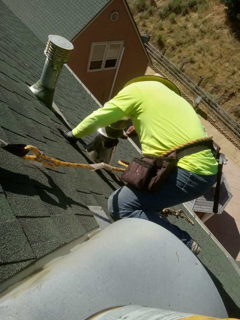 Trabajador realizando labores sobre el techo residencial